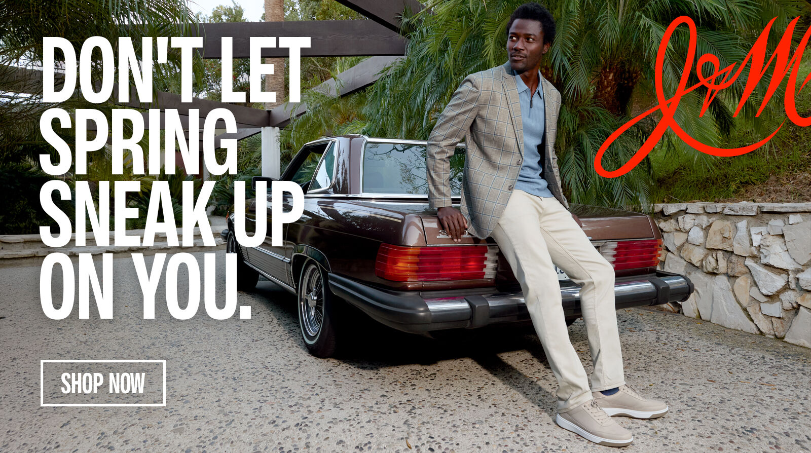 Man leaning on a vintage brown car wearing outfit styled by Johnston & Murphy. Don't Let Spring Sneak Up On You with a Shop Now button below. 